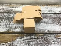 Stack of flat die-cut box blanks with one assembled cube