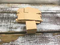 Stack of flat cardboard box blanks with one assembled to show size