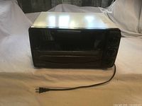 Front view of DeLonghi convection oven with power cord visible