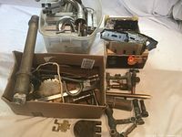 Overall view of two boxes and plastic bin filled with mixed metal hardware pieces.