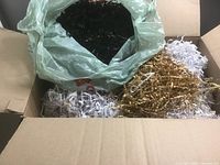 Open box showing white, brown, and bagged black crinkle paper