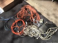 Pile of assorted orange, blue-grey, white and beige extension cords with metal timer box
