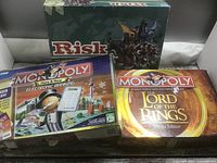 Front view of all three boxed games: Risk, Monopoly Here & Now Electronic Banking, Monopoly Lord of the Rings