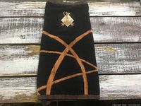 Full view of black towel with orange arcs and logo