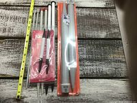 Overall view of knitting needles including measuring tape for scale