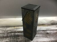 Full view of rectangular metal lantern with leaf motif