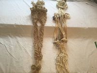 Full view of both macrame plant hangers laid flat