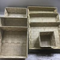 View of all seven woven beige baskets stacked by size