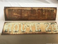 Both metal signs showing text and distressed condition