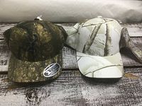 Two camo hats side by side on table