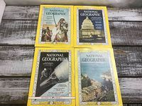 Four National Geographic magazines laid out, showing full covers