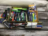 Overview of tray with assorted writing instruments and bundled pencils