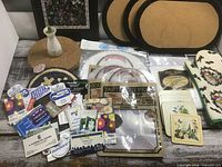 Overall lot showing placemats, trivet, vase, packaged items and magnets