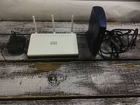 D-Link router with adapter and Motorola router side by side