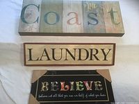 Overview of Coast, Laundry and Believe signs