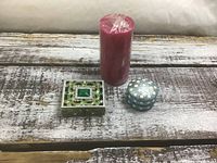 All three items: pink wrapped pillar candle, square brass-tone trinket box, round cloisonné trinket box