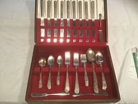 Open case showing full contents: knives in lid, assorted forks and spoons in tray