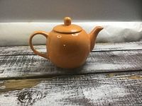 Side view of the orange ceramic teapot