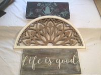 Three wall decor pieces arranged together: coffee sign, half-round panel, life is good sign