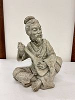 Front view of seated Asian musician stone figurine