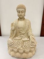 Front view showing seated Buddha on lotus base with hand gestures