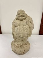 Front view of concrete Buddha statue showing overall form and surface condition