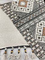 Close-up of folded rug displaying weave detail, color palette and reversible sides