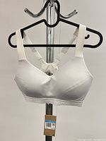 Front view of white Nike Indy sports bra on hanger with tag attached