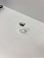 Front view of sterling silver rat ring on clear stand