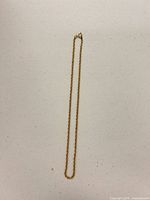 Full view of gold-tone rope chain necklace laid flat