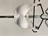 Side profile of white racerback sports bra on hanger