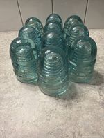 Nine of the ten aqua G.T.P. TEL CO. insulators standing upright