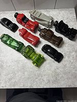 Nine assorted Avon car decanters arranged on countertop