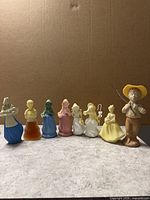 Front view of all eight Avon figurine bottles lined up