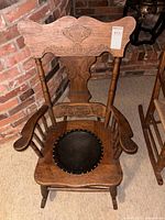 Full view of rocking chair front angle showing pressed back design and leather seat