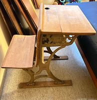Left side view showing wood top, seat, and cast iron frame