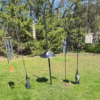 Four shepherd’s hooks with baffles, wind chime, wood feeder visible