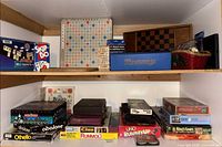 Shelf view showing Scrabble board, Rummy set, Skip-Bo, wooden chess board and magnetic games stack