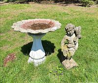 Bird bath and cherub statue on lawn
