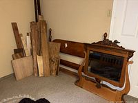 Headboard, mirror, assorted boards leaning against wall