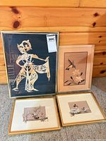 Group shot of all four framed artworks on carpeted floor