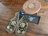All three items: carved table, embroidered vest, framed zebra art