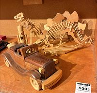 overall view showing wooden car, stegosaurus skeleton puzzle and second puzzle