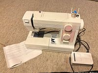 Full view of Janome Limited Edition sewing machine with foot pedal, paperwork