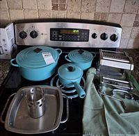 Group shot of all cookware, pasta maker and roaster on stove