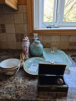 All items on counter showing platter, ginger jar, vases, bowls, plates, spoons, trinket box