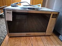 Front view of Panasonic microwave showing door, control panel and MaxSold tag