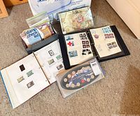 Albums, coin set, loose stamp packets spread on floor