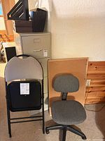 Front view of filing cabinet, chairs, cork board and organizers