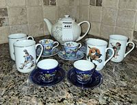 Group shot showing all pieces: teapot, four Norman Rockwell mugs, two Copeland Spode cups with saucers, two cobalt blue mini cups with saucers